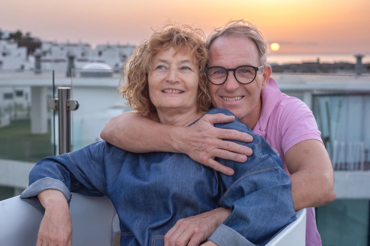 Coppia di pensionati in Grecia sul terrazzo di casa al tramonto